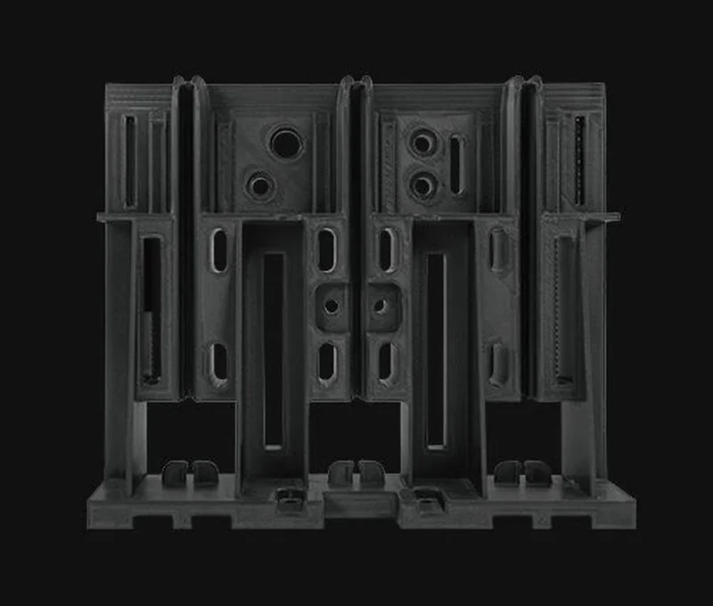 Black 3D printed component with complex geometric design made by raise3d rmf500 against a dark background.