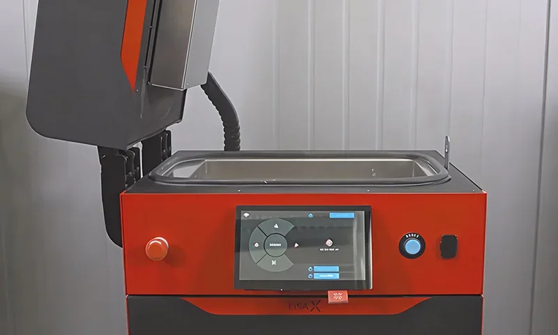 Sinterit Lisa X 3D printer with open chamber and touchscreen interface showing menu options, set in an industrial environment.