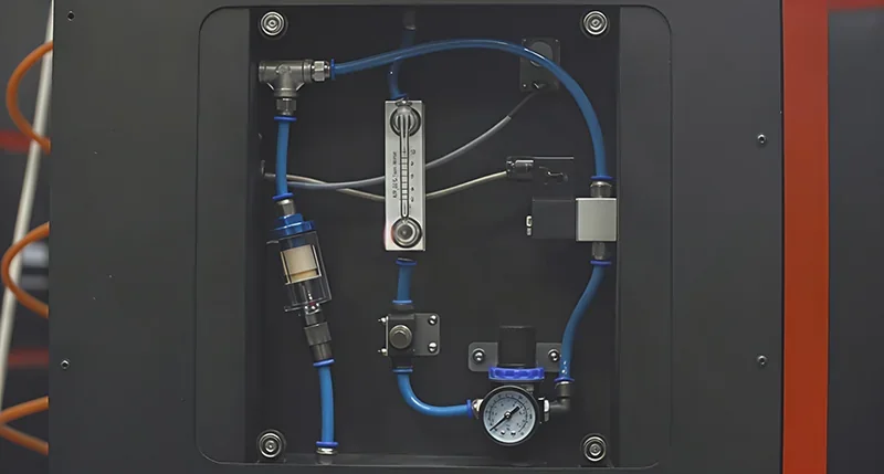 Sinterit Lisa X internal view showing tubing, pressure gauge, and fittings assembled in a compartment, highlighting technical components.