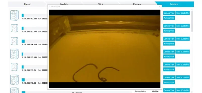 Sinterit Lisa X 3D printer interface displays live camera view of ongoing print, showing parts being created. Multiple printer controls are visible.