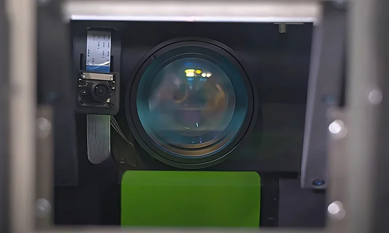 Sinterit Lisa X printer interior showing lens, camera, and components essential for sample creation, viewed through an operating chamber.