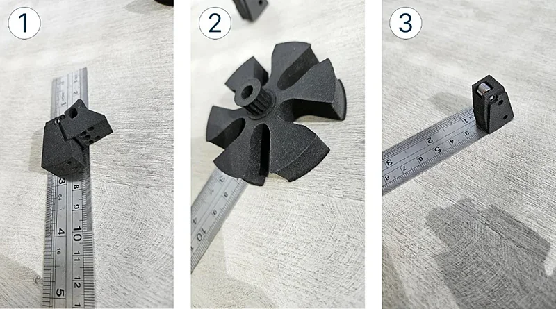 Sinterit Lisa X 3D-printed black parts on a ruler, showcasing precision detail and measurements, highlighting sample output capability.