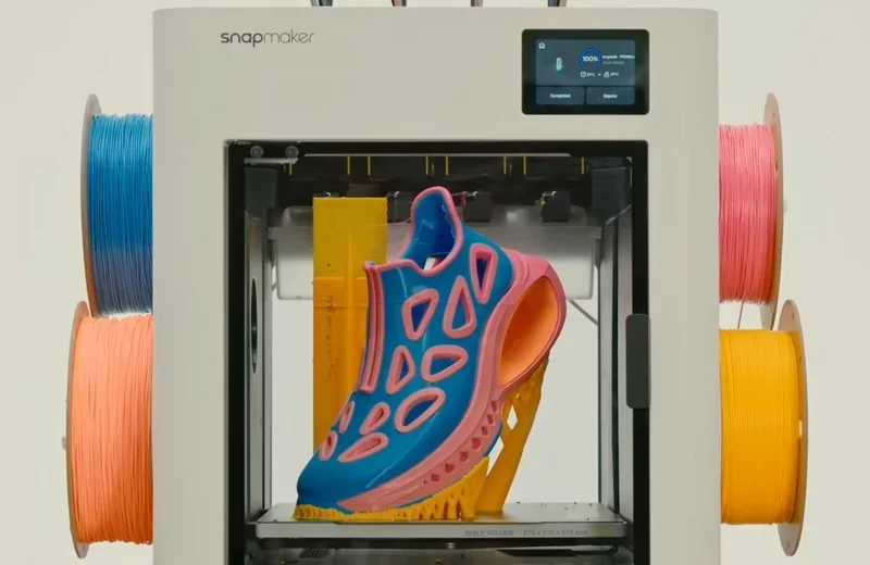 Snapmaker U1 3D printer showcases a colorful shoe print, surrounded by vibrant filament spools on each side, perfect for creative projects.