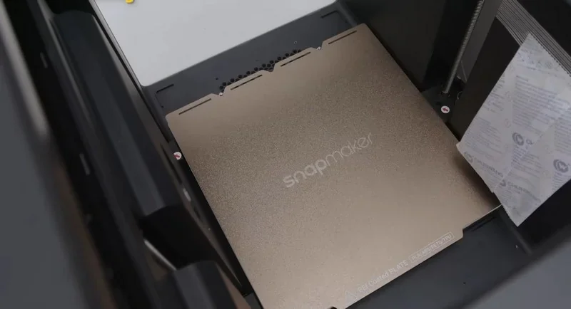 Snapmaker U1 3D printer with a golden build plate inside; snapmaker branding visible, set up for creating print samples.