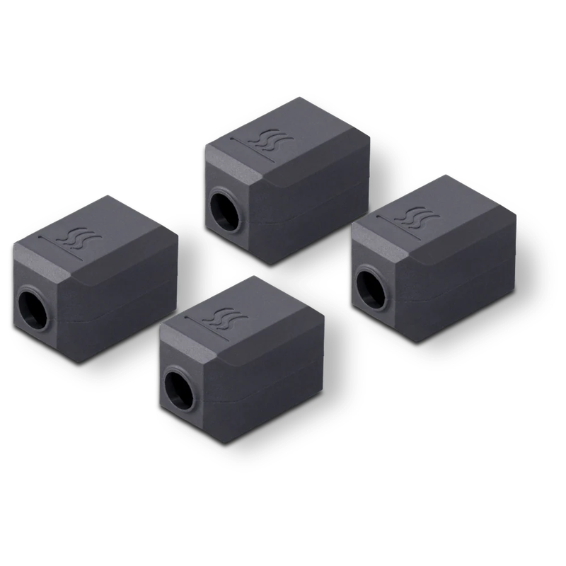 Four black rectangular components with indented symbols, likely parts created by the Snapmaker U1 3D printer, arranged diagonally on a white background.