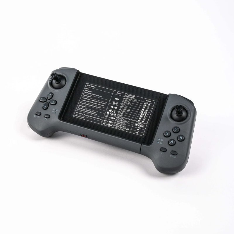 A sleek, black handheld controller with dual joysticks, one on each end, reflective of a gaming console design. The center features a digital display showing button configurations and control settings. The left side includes four-directional arrow buttons, while the right showcases labeled action buttons: X, Y, B, and A. The unit, with its ergonomic design, is placed on a white background, emphasizing its smooth texture and modern aesthetic suitable for controlling robotics or gaming devices.