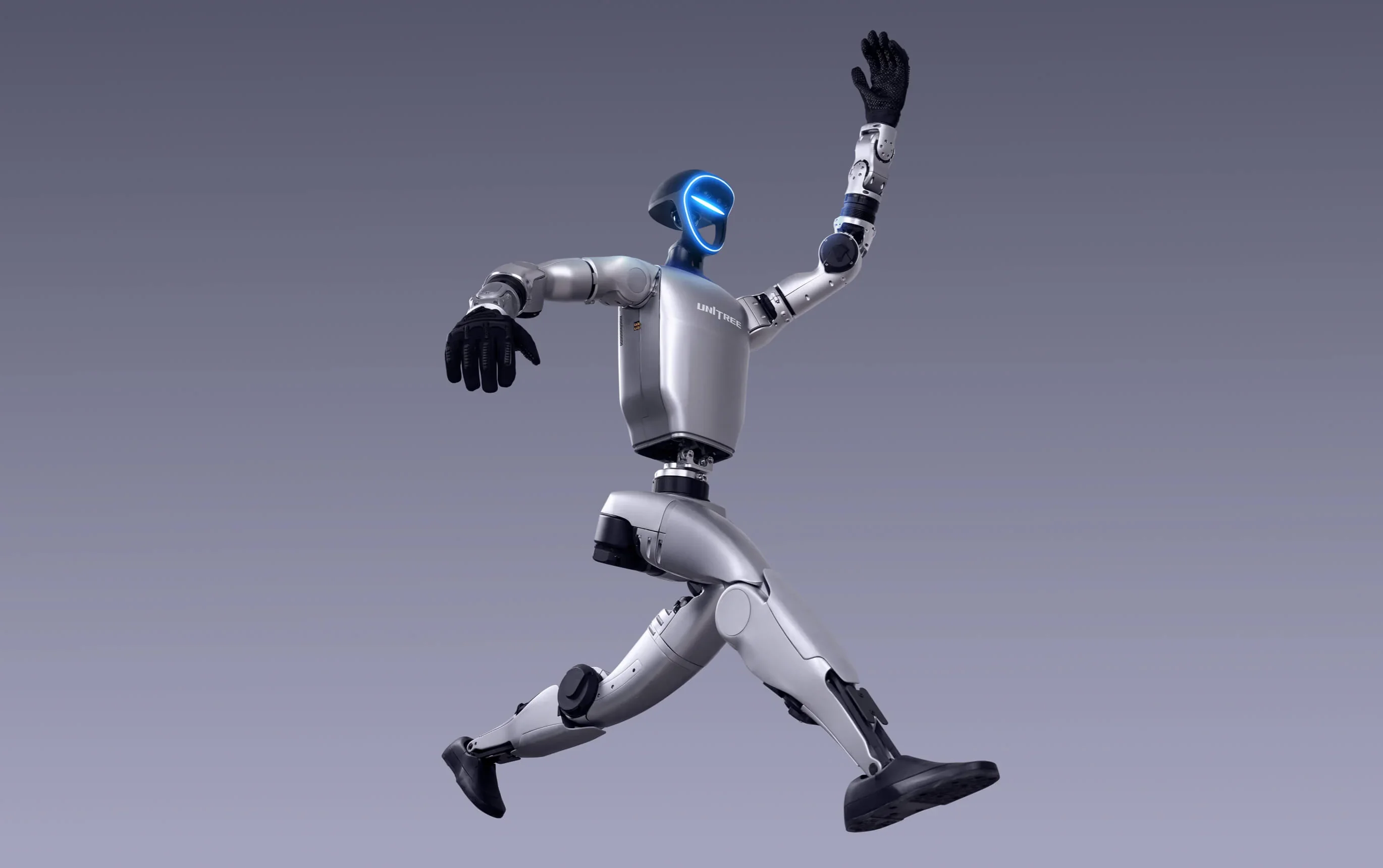 Unitree G1 humanoid robot jumping with dynamic pose, sleek metallic body, glowing blue faceplate, and visible Unitree branding against a gray background.